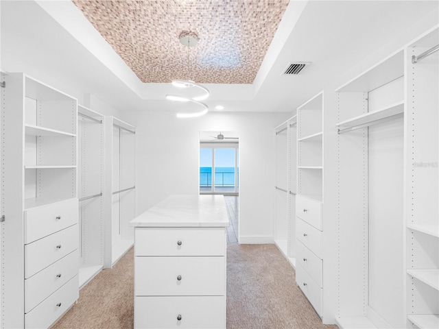 19816 Gulf Blvd Unit 602, Indian Shores, FL 33785 - walk in closet with light colored carpet, ceiling fan, visible vents, and a raised ceiling