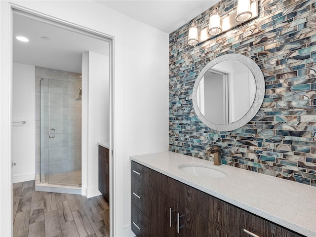 19816 Gulf Blvd Unit 602, Indian Shores, FL 33785 - full bathroom with a stall shower, baseboards, decorative backsplash, wood finished floors, and vanity