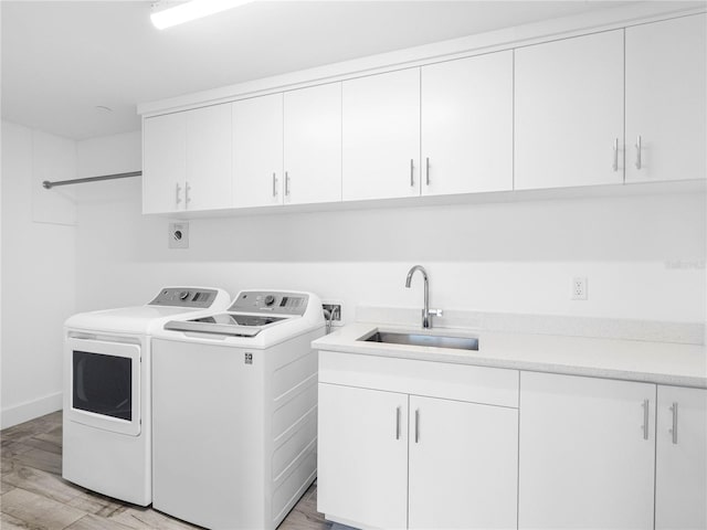 19816 Gulf Blvd Unit 602, Indian Shores, FL 33785 - washroom with a sink, independent washer and dryer, light wood-style floors, baseboards, and cabinet space