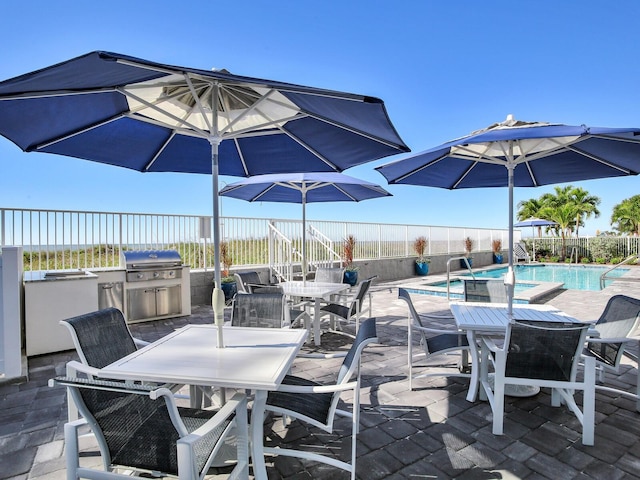 19816 Gulf Blvd Unit 602, Indian Shores, FL 33785 - view of patio / terrace with outdoor dining area, a community pool, a fenced backyard, and grilling area
