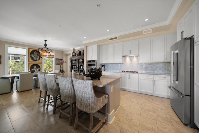 145 Belleview Blvd Unit 201, Belleair, FL 33756 - kitchen featuring ornamental molding, a kitchen breakfast bar, high end fridge, white cabinetry, and gas cooktop