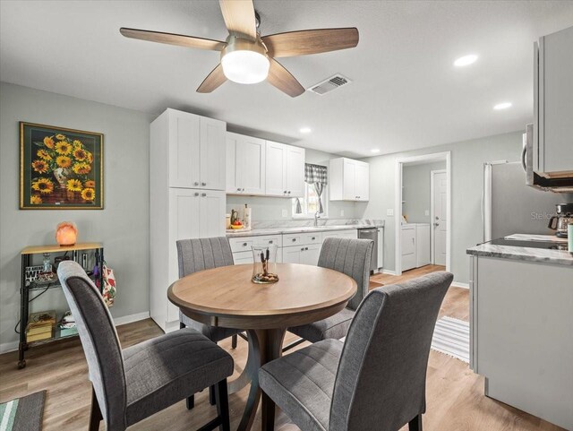 16116 Manorwood Cir, Tampa, FL 33624 - dining area with baseboards, washing machine and dryer, visible vents, ceiling fan, and light wood finished floors