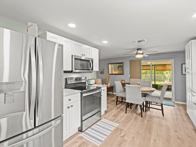 16116 Manorwood Cir, Tampa, FL 33624 - kitchen with light countertops, ceiling fan, white cabinetry, stainless steel appliances, and light wood-style flooring