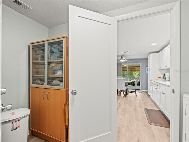 16116 Manorwood Cir, Tampa, FL 33624 - hall featuring visible vents, a textured ceiling, and light wood-style flooring