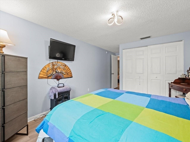 16116 Manorwood Cir, Tampa, FL 33624 - bedroom with visible vents, a closet, a textured ceiling, and wood finished floors
