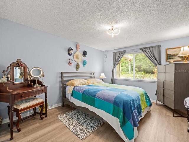 16116 Manorwood Cir, Tampa, FL 33624 - bedroom with light wood-style flooring, baseboards, and a textured ceiling