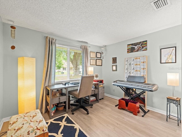 16116 Manorwood Cir, Tampa, FL 33624 - office area featuring light wood-style flooring, a textured ceiling, baseboards, and visible vents