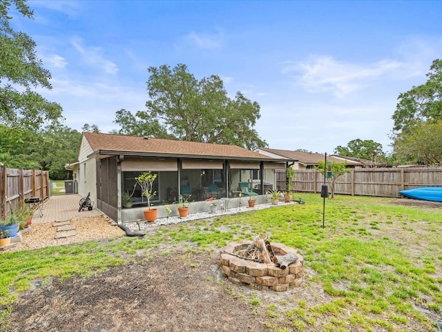 16116 Manorwood Cir, Tampa, FL 33624 - back of property featuring a sunroom, a fenced backyard, an outdoor fire pit, and a lawn