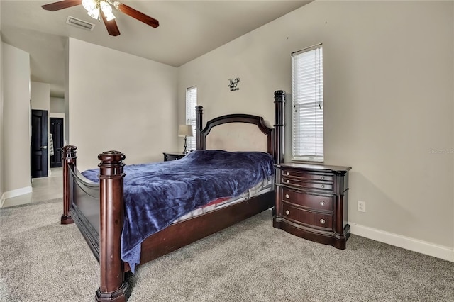 carpeted bedroom with baseboards, a ceiling fan, and visible vents