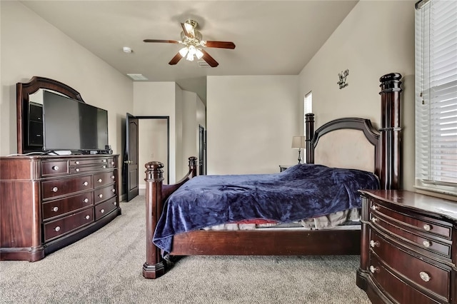 bedroom with visible vents, light colored carpet, and ceiling fan