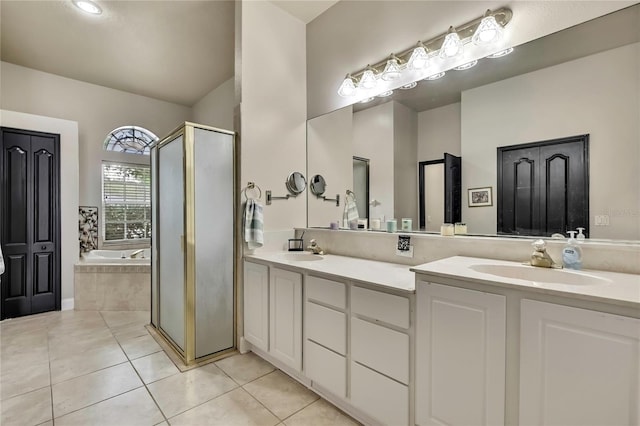 full bathroom with a sink, a shower stall, double vanity, tile patterned flooring, and a garden tub