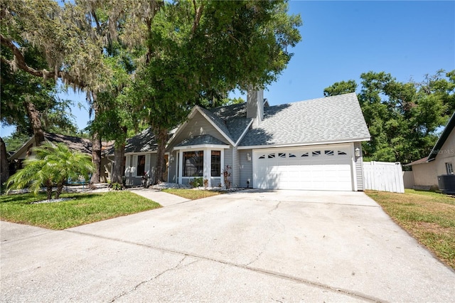 1916 River Crossing Dr, Valrico, FL 33596 - view of front facade with fence, driveway, roof with shingles, a front yard, and a garage