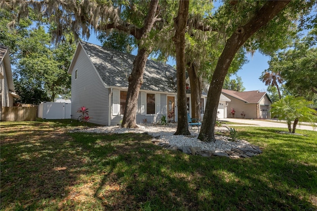 1916 River Crossing Dr, Valrico, FL 33596 - view of front of home featuring fence, a front lawn, driveway, roof with shingles, and a garage