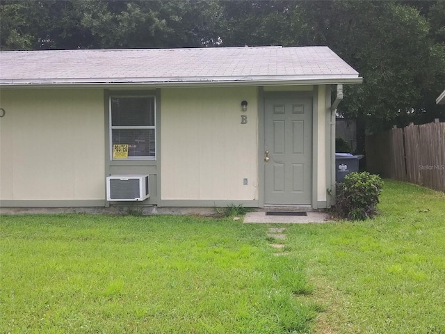 2810 Anthony St, Tampa, FL 33619 - view of exterior entry with a yard, a wall mounted air conditioner, and fence