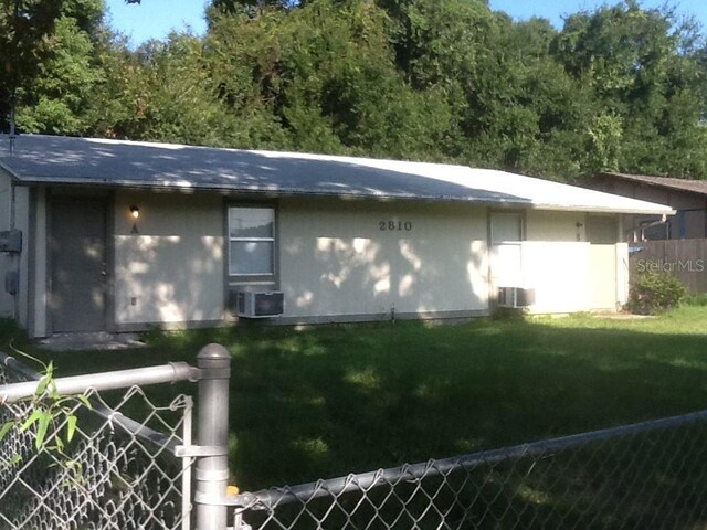 2810 Anthony St, Tampa, FL 33619 - view of property exterior with central air condition unit, fence, and a lawn