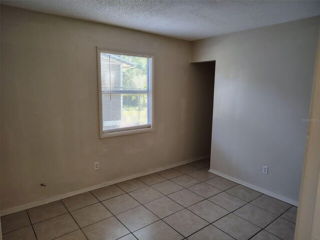 2810 Anthony St, Tampa, FL 33619 - spare room with light tile patterned floors, a textured ceiling, and baseboards