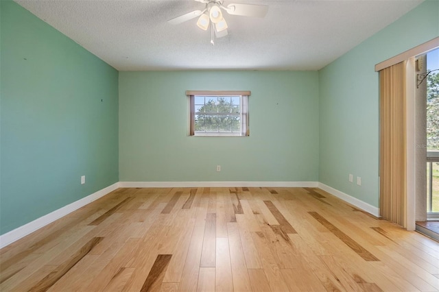 unfurnished room featuring a ceiling fan, a healthy amount of sunlight, and wood finished floors