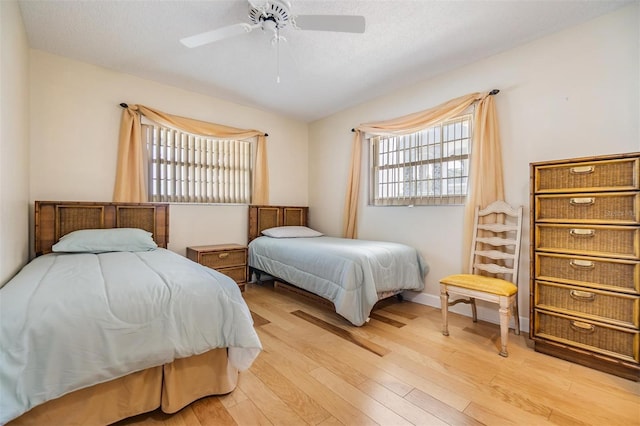 bedroom featuring light wood-style floors, baseboards, and ceiling fan