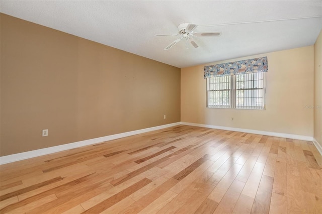 empty room with light wood-type flooring, baseboards, and ceiling fan