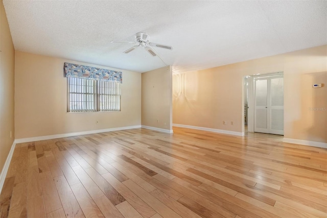 spare room featuring baseboards, ceiling fan, and light wood-style flooring