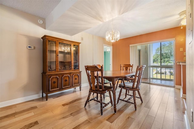 dining room featuring baseboards, an inviting chandelier, and light wood-style floors
