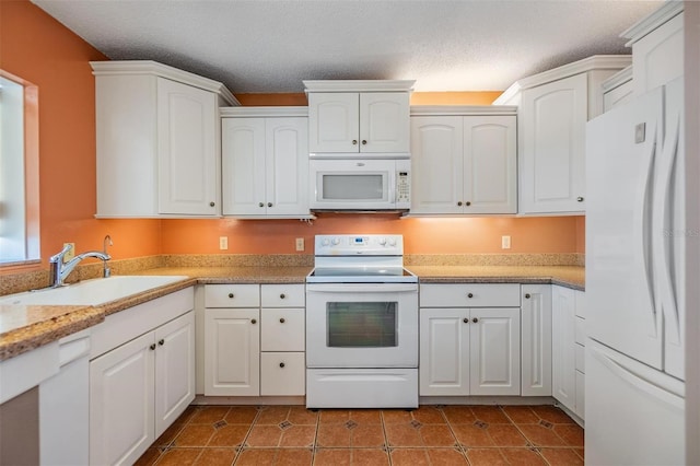kitchen with a sink, white cabinets, white appliances, and a textured ceiling