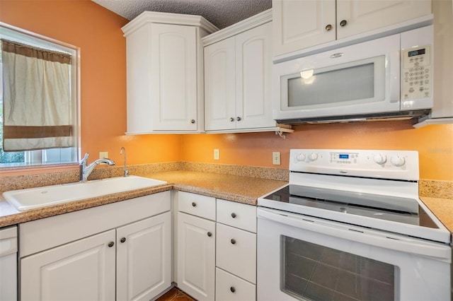 kitchen with a sink, white cabinetry, white appliances, and light countertops
