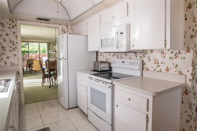 2630 Pearce Dr Unit 104, Clearwater, FL 33764 - kitchen featuring white appliances, visible vents, light countertops, and wallpapered walls