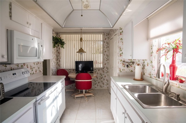 2630 Pearce Dr Unit 104, Clearwater, FL 33764 - kitchen featuring light tile patterned floors, white appliances, light countertops, a sink, and wallpapered walls