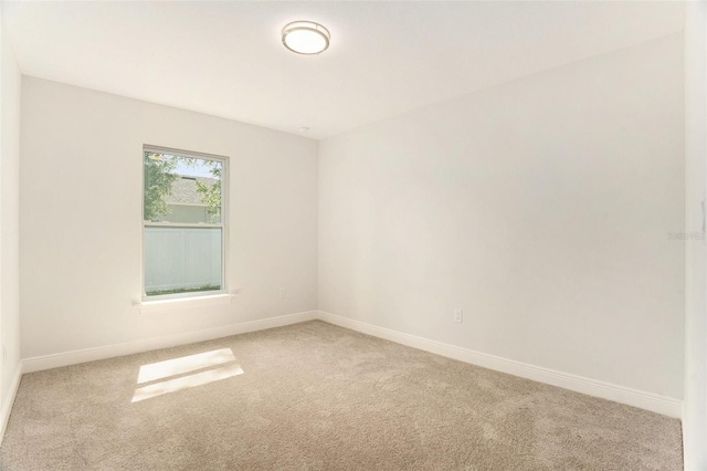 carpeted spare room with baseboards