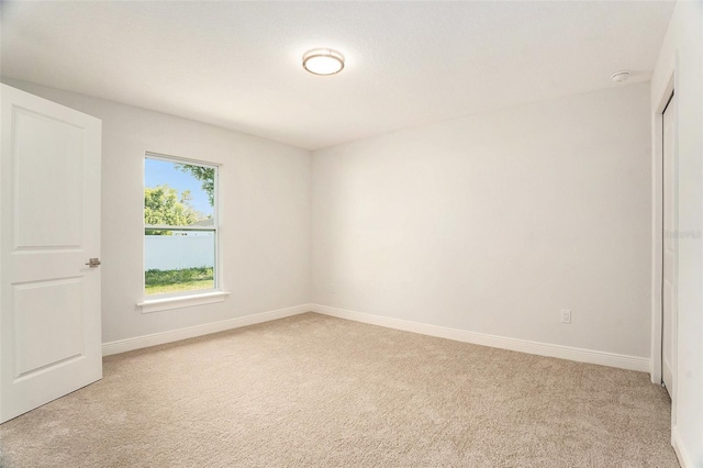 unfurnished bedroom with baseboards and light carpet