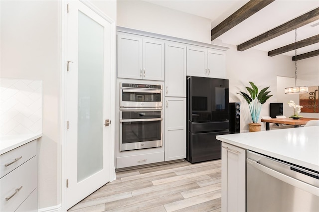 kitchen with light wood-style floors, stainless steel appliances, beamed ceiling, light countertops, and decorative light fixtures