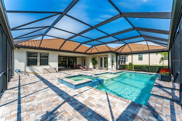 view of pool with glass enclosure, french doors, a pool with connected hot tub, and a patio