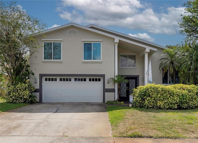 view of front of property with a front lawn, driveway, stucco siding, and a garage