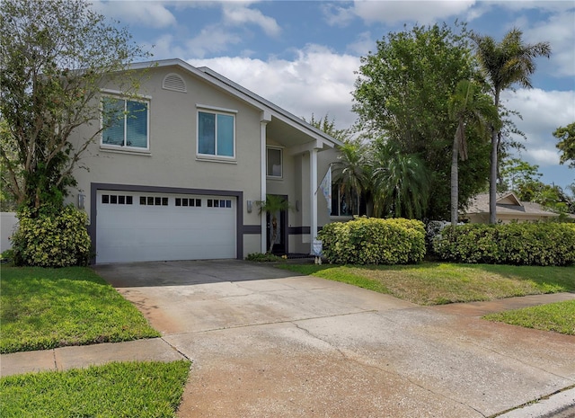 view of front facade with driveway, an attached garage, stucco siding, and a front yard