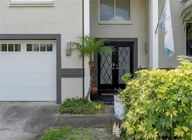 entrance to property with stucco siding and a garage