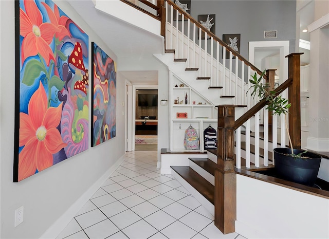 stairway featuring tile patterned flooring, baseboards, and visible vents
