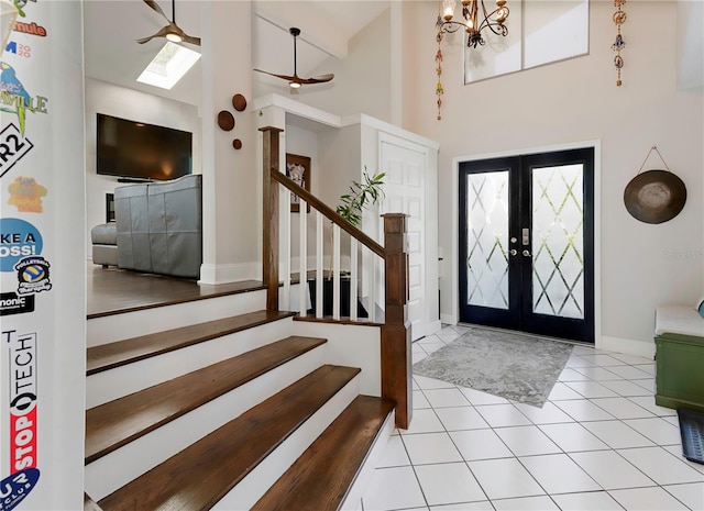 entryway featuring stairs, french doors, light tile patterned flooring, high vaulted ceiling, and baseboards