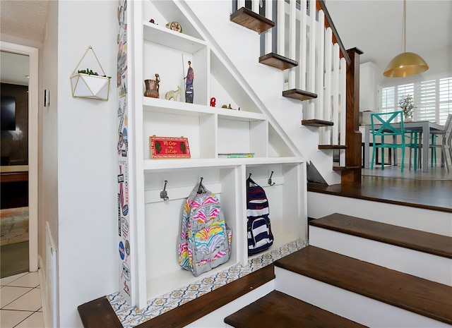 stairway with tile patterned floors