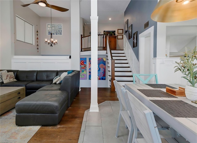 living room with ceiling fan with notable chandelier, decorative columns, visible vents, stairway, and recessed lighting