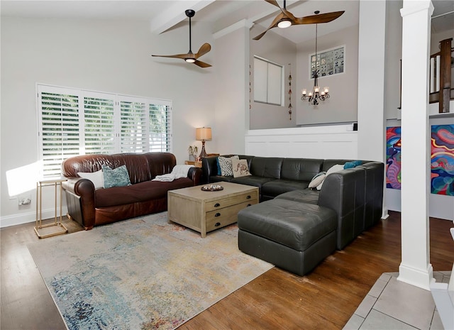 living room with wood finished floors, ceiling fan with notable chandelier, high vaulted ceiling, decorative columns, and beamed ceiling
