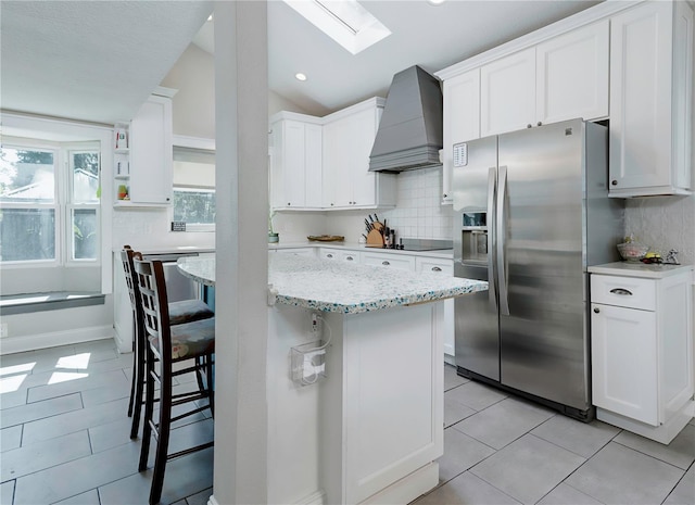 kitchen with premium range hood, a kitchen breakfast bar, open shelves, black electric cooktop, and stainless steel fridge with ice dispenser