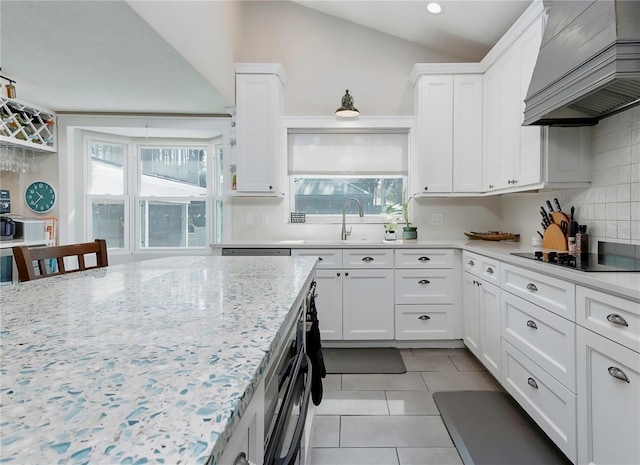 kitchen with light tile patterned flooring, custom range hood, decorative backsplash, black electric cooktop, and white cabinets