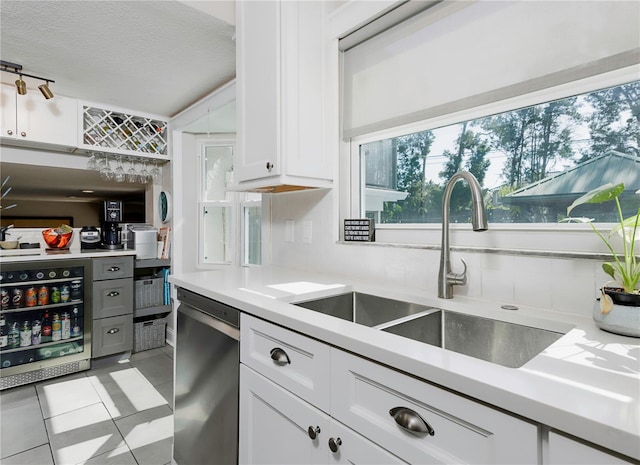 kitchen featuring a sink, white cabinetry, light countertops, and dishwasher