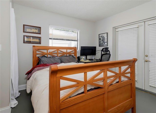bedroom with a textured ceiling and baseboards