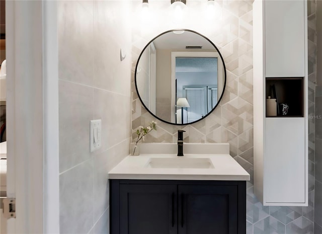 bathroom with tile walls, vanity, and backsplash