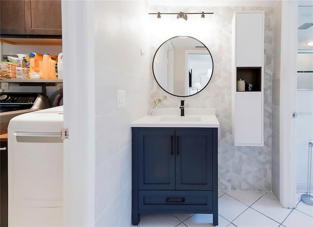 bathroom with vanity, tile walls, tile patterned flooring, and separate washer and dryer