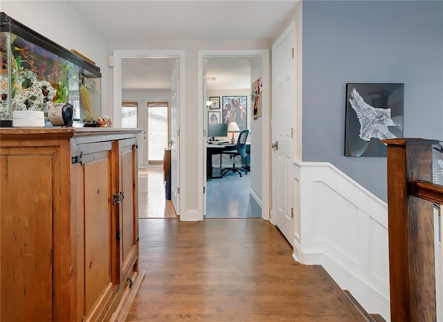 hallway with wainscoting and wood finished floors