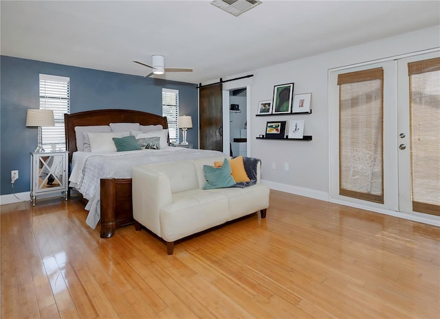 bedroom featuring a barn door, access to exterior, visible vents, and multiple windows