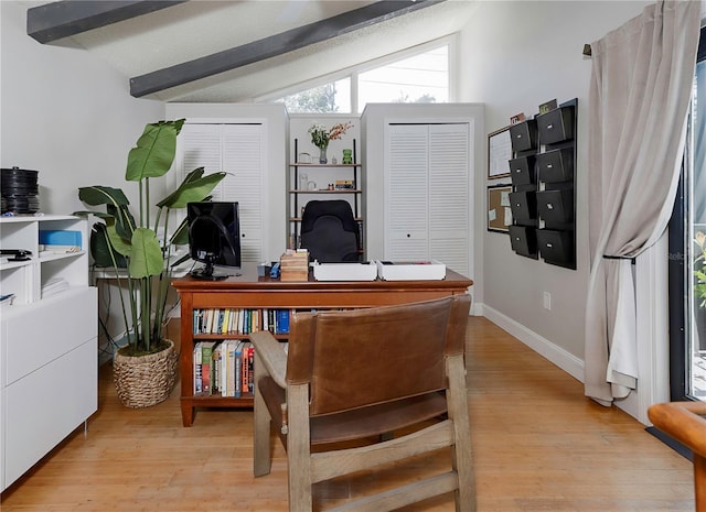 office area with baseboards, lofted ceiling with beams, and light wood-style flooring